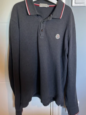 Moncler pique långärmad - Säljer min riktigt snygga Moncler pique som är 100% äkta. Köpte den från garmsmarket för ca 1 år sedan. Hittar inte kvitto tyvärr men man kan verifiera äktenheten på loggan på brösetet och tagsen inuti. Har tagit hand om den väldigt väl så den ser fortfarande som ny ut. Bara att höra av er vid fundering eller bilder eller liknande.