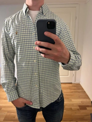 Rutig Ralph Lauren skjorta grön och vit  - Säljer denna sjukt snygga skjortan från Ralph Lauren⭐️ Färgen är mörkblå och storleken är M✅ Den har inga grön och vit och skicket är utomordentligt🙌🤝 Sjukt najs passform och passar perfekt till sommaren☀️🙌 Tveka inte på att höra av er dig vid minsta fråga eller fundering😊