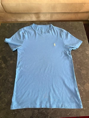 Blå t-shirt från Ralph Lauren - Ljusblå RL t shirt, bra skick inga fläckar eller defekter. Storlek S custom slim fit.