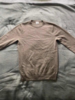 Beige cashmere tröja från John Henric - Säljer en stilren beige stickad tröja från John Henric i 100% cashmere. Tröjan har rund halsringning, långa ärmar och ribbade muddar vid ärmslut och nederkant. Perfekt för dig som gillar mjuka och exklusiva material.