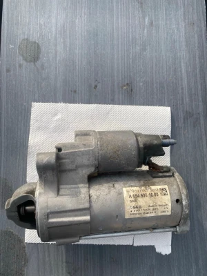 Startmotor Mercedes-Benz grå metall - Startmotor i grå metall från Mercedes-Benz, modellnummer A 654 906 16 00. Märkt med SEES och tillverkad i Ungern. Kompakt och robust design, passar till bilmotorer från Mercedes.