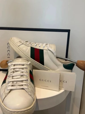 Gucci ace vita skor - Säljer ett par vita gucci ace sneakers. Fint skick och väldigt bra pris. Hör mer än gärna av dig om fler bilder önskas eller om du har frågor. 