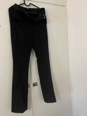 Svarta kostymbyxor från BikBok - Stilrena svarta kostymbyxor från BikBok. Perfekta för en clean och snygg look. Byxorna är lätta att matcha med olika toppar och skor. Köpta i fel storlek därav säljer jag de.