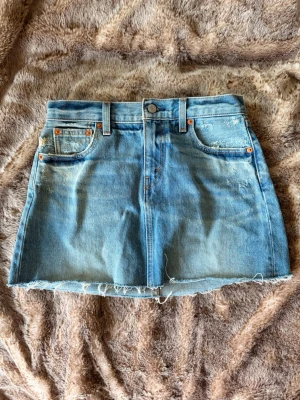 Washed blå lågmidjad jeanskjol från Levi's - W 26, trendig lågmidjad jeanskjol från Levis ☀️🙌 Pris kan diskuteras💕
