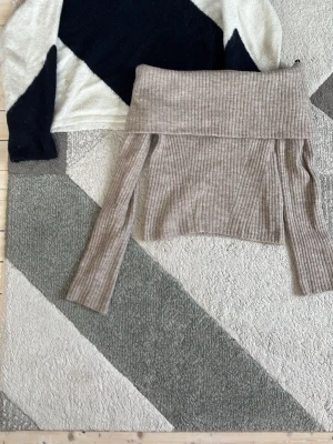 Stickade tröjor - Trendig beige ribbstickad tröja från H&M i off shoulder-modell och en stickad från Gina tricot. Mjuk och skön med långa ärmar och bred krage som viks ner över axlarna. Perfekt för dig som gillar en stilren och avslappnad look.