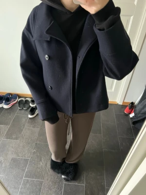 Kort marinblå kappa med knappar - Snygg kort marinblå kappa med dubbelknäppning och bred krage. Köpt från Gina tricot för ca 2 år sedan. Perfekt för dig som gillar en klassisk men trendig look.