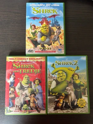 Shrek dvd paket - En samling med tre filmer från Shrek-serien på DVD: Shrek, Shrek 2 och Shrek Tredje. Alla filmer är i DVD-format.  Alla finns på språk: Svenska, Engelska, Finska   OBS!! skivorna är begagnade så det kan förekomma repor/hairlines på skivorna, men då jag kollar igenom alla filmer jag säljer garanterar jag att alla funkar felfritt om inget annat står! :)