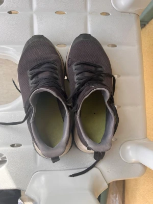 Svarta Puma sneakers med mesh - Svarta sneakers från Puma med ovandel i mesh och klassisk snörning. Skorna har vit sula och diskret Puma-logga på hälen. Perfekta för en sportig och avslappnad stil.