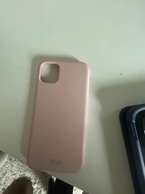 Fint ljusrosa mobilskal iphone 11/12 - Jag säljer ett gulligt rosa skal från sign och är till iphone 11 och 12. Det är ett litet märke på sidan (se bild) men inget jag tycker att man tänker på. Skriv för frågor💓💓