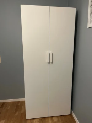 Vit garderob (OBS! Denna garderob hämtas och lämnas eller skickas ej! - Denna vita garderob är ifrån ikea och har använts några år, det kan man se det och om ni kollar på bilderna ser ni dem eventuella märkena man kan se men annars är den väldigt användbar. Bredden är 80 cm och höjden är 180cm. De finns två lådor som man kan ha kläder i och dra ut, några av märkena kommer från att ha dragit ut lådan! De finns en stång i mitten där man kan hänga kläderna och även den har några skromor! Kontakta mig om ni har några frågor eller om ni är intresserade!  Mvh Lea☺️ 