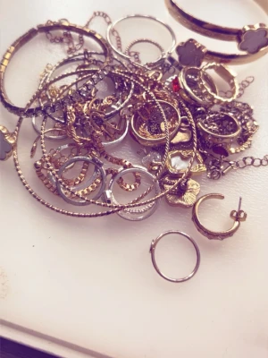 FLERA olika smycken  - Jag säljer flera olika smycken. Från armband till halsband, ringar och örhängen. Finns i guld och silver. Det finns JÄTTE många fler smycken som ingår men jag kunde inte lägga fler bilder. 4 par örhängen. 6 stycken halsband. 6 guld ringar och 10 silver ringar. 12 armband.  För mer detaljer kontakta mig. 😊