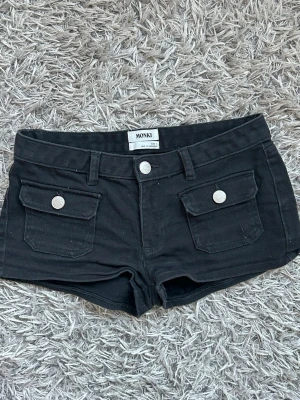 Svarta shorts med fickor från Monki - Supersnygga svarta shorts från monki. Ganska små i storleken så kan nog passa 32 också!!