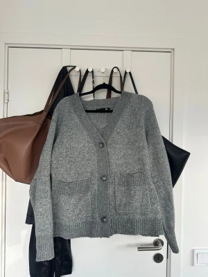 Grå kofta med knappar och fickor - Aldrig använd 