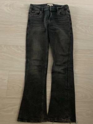 Mörkgrå bootcut jeans med rå kant - Säljer ett par mörkgrå bootcut jeans med rå och fransig kant längst ner. Jeansen har klassiska fem fickor. Dom är verkligen jätte skön och lågmidjade🤗