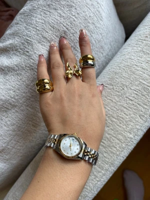 28mm Klassisk tvåtonad klocka i silver och guld, rostfritt stål. Märke syns - Snygg klocka med länkarmband i silver och guldton. Silver urtavla, guldfärgade visare och index. Boetten är rund och har en räfflad guldkant. Perfekt accessoar för dig som gillar stilrena detaljer.