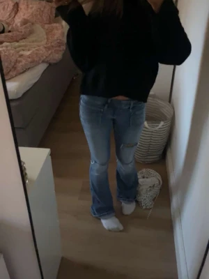 Blå bootcut jeans med slitningar - Säljer ett par blå bootcut jeans med slitningar på knäna. Slutsålda i alla storlekar på Gina. Inga defekter 