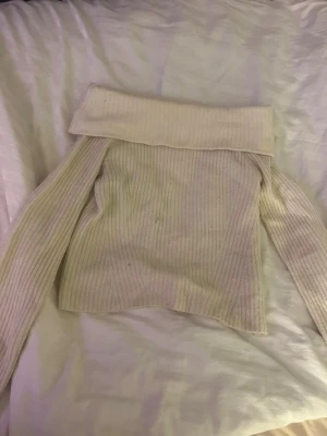 Offshoulder stickad tröja i gräddvit - Säljer en ribbstickad offshoulder tröja i gräddvit med bred krage. Tröjan har långa ärmar och är gjord i ett mjukt stickat material som är perfekt för kyliga dagar. Passar dig som gillar en avslappnad och trendig look. Från H&M storlek M men sitter bra på mig som brukar ha XS-S. Säljer pågrund av att den ej används längre ❤️