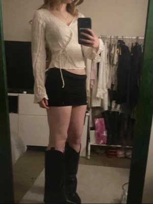 Svart tight kortkjol - En vit top med knytning. Knappen har lossat lite men det är bara och sy på