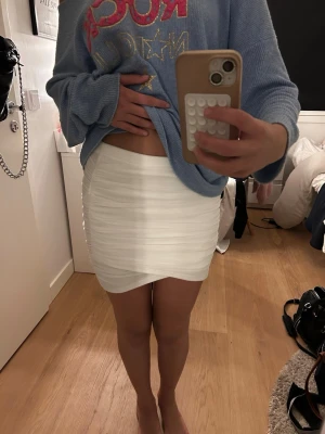 Super snygg tjol - Säljer en offwhite tight minikjol med snygg drapering och omlott-detalj framtill. Kjolen har en kroppsnära passform och är gjord i ett stretchigt, tunt material som känns bekvämt. Perfekt för dig som gillar trendiga och stil ren looks. Har knappt använt den