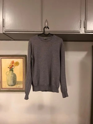 Armani Collezioni Sweatshirt - En enkel och stilren grå tröja med rund halsringning och långa ärmar. Tröjan är tillverkad i mjuk bomull och har ribbade muddar vid ärmslut och nederkant. Perfekt för en clean och avslappnad look.