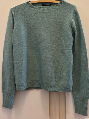 Ljusblå stickad tröja Teranova - En stilren ljusblå stickad tröja från Teranova med rund halsringning och ribbade muddar vid ärmslut och nederkant. Storlek M. 
