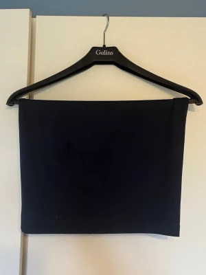 Mörkblå tight tubkjol - En enkel och stilren mörkblå tubkjol i tight passform. Kjolen är kort och har en minimalistisk design utan detaljer eller mönster. Perfekt att matcha med olika toppar för en clean look.