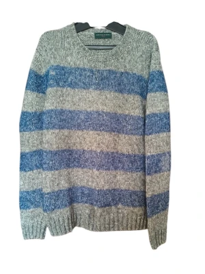 Randig stickad tröja  - Stickad tröja från Polo Ralph Lauren i grått och blått med breda horisontella ränder. Tröjan har rund halsringning, långa ärmar och ribbade muddar. Perfekt för dig som gillar klassisk och avslappnad stil.