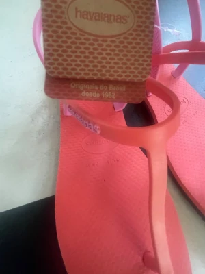 Korallrosa sandaler från Havaianas - Säljer ett par snygga korallrosa sandaler från Havaianas med tunna remmar i ljusrosa. Tillverkade i mjukt och flexibelt gummi som är perfekt för sommaren. Klassisk Havaianas-logga på remmen och präglad sula för extra grepp. Köptes sommaren 2025 i Brasilien men har inte använts sedan dess. 