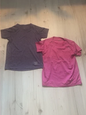 Två sportiga t-shirts från Haglöfs - Två snygga t-shirts från Haglöfs i storlek 150, en i Lila och en i rosa. Märket har försvunnit lite från den rosa tröjan men det finns bilder. Skriv om du bara är intresserad av en tröja så fixar vi det:)