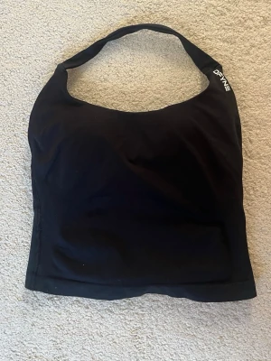 Svart sportlinne från DFYNE - Snyggt svart sportlinne från DFYNE med breda axelband och logga tryckt både fram och bak.  Använd 1 gång, annörs helt ny!!