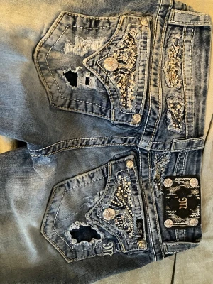 Bootcut miss me jeans - Ett par ljusblåa jättesnygga lågmidjade och bootcut miss me jeans. De är i en liten xs eller xxs och har superfina fickor med detaljer och knappar. De är i w25. Säljer då de tyvärr är för små för mig🥲. De är i jättebra skick men har några lagningar i grenen som inte syns när de är på och två små fläckar som är nästintill osynliga. Jag kan skicka bild på fläckarna om man vill då det inte gick att lägga in mer än 7 bilder. De är en aning korta för mig som är 162. 💕