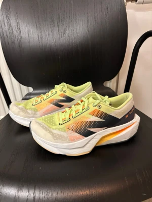 New Balance FuelCell V4 - Säljer ett par limegröna New Balance sneakers med orange och svarta detaljer. Skorna har en chunky vit sula och ovandel i mesh för bra ventilation. Snygg design med tydliga loggor på sidan och coola färgkombinationer som sticker ut. 