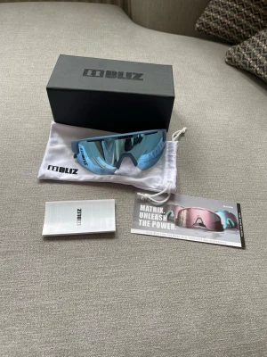 Bliz Matrix Sportglasögon – Nyskick – Komplett med box - Säljer ett par Bliz Matrix sportglasögon i nästan nyskick. Använda väldigt lite, inga repor på glasen.  Kommer komplett med: • Originalbox • Skyddspåse • Extra tillbehör  Perfekta för löpning, cykling, skidåkning eller annan träning.  • Skick: Nyskick • Modell: Matrix • Färg: Blå / spegelglas  Nypris ligger runt 1200 kr.   