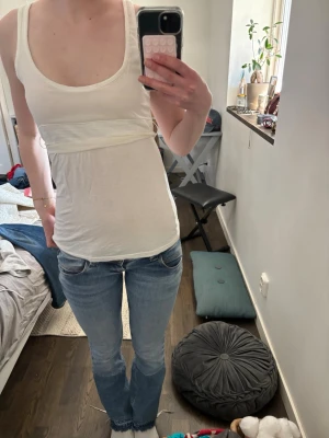 Vit linnetopp med knytband - Säljer en vit topp med knyt bak. Köpt i Spanien förra året. Den är väldigt fin med jeans eller jeanskjol. Väldigt enkel att styla. Det finns två mindre hål på övre ryggen (sista bilden) men de syns väldigt lite när den är på och går enkelt att sy.