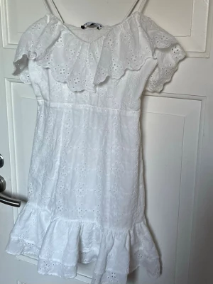 Vit sommarklänning med volanger - Söt vit klänning med tunna axelband och volangdetaljer vid axlar och nederkant. Formar sig fint runt höfterna och passar perfekt till studenten, skolavslutningen eller midsommar 🌸💐🤍