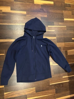 Marinblå hoodie från Polo Ralph Lauren - Snygg marinblå hoodie från Polo Ralph Lauren extremt bra hoodie för att ha på sig på lite kyligare kvällar eller på morgonen till skolan 