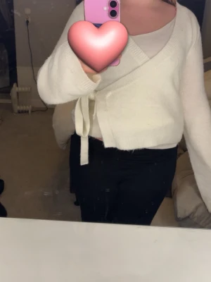 Vit omlottkofta med knytband från lager 157 - Säljer en supermjuk vit omlottkofta med knytband den är i jättebra skick och jag säljer den för att har inte så stor användning till den har använt typ 3 gånger original pris är ungefär 250kr och de jag säljer den för är 169kr