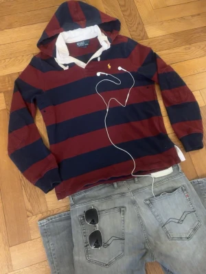 Vintage Rugby Hood Ralph Lauren  - Grym kvalité, inga defekter. Storlek S sitter bra vid axlarna och slutar vid midjan. Luvan är stor.   Mått -|-  Axelmått: 47 cm  Längd: 66cm  Bröst: 54 cm  Arm: 63 cm  Leverans sker dagen efter, har du nån fråga är det bara att skriva:)