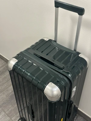 OCCA Resväska Trunk i mörkgrön - Resväska i mörkgrön färg med fyra hjul och teleskophandtag. Väskan har ett kombinationslås och bärhandtag på både ovansidan och sidan. Insidan är fodrad med svart tyg och har packband samt ett avdelande fack med dragkedja. Storlek 780x390x390 och 105L