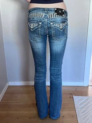 Miss Me low waist jeans 25 - Supersnygga lågmidjade jeans med bootcut i storlek 25 från MissMe. Säljer för att jag tröttnat på dom. Sparsamt använda, men det finns en lös tråd i grenen (se bild 7). Den skapar inget hål! Dock inget som syns när man har på sig. Nästan inte alls slitna nertill! Uppsydda nertill (ej av oss), modellen på bilden är ca 169 cm lång och jeansen passar i längden perfekt.