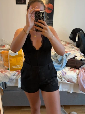 Svarta shorts med bälte - Stilrena svarta shorts med hög midja. Klassisk design med fickor och en dressad känsla, perfekta för sommardagar. Passar till både linne och blus för en trendig look. Helt nya