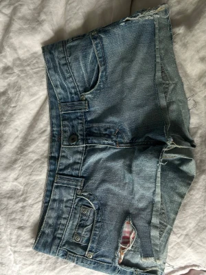 Blå jeansshorts från American eagle!  - Säljer ett par klassiska blå jeansshorts med råa kanter och slitningar. Jättesnygga och från American eagle! 
