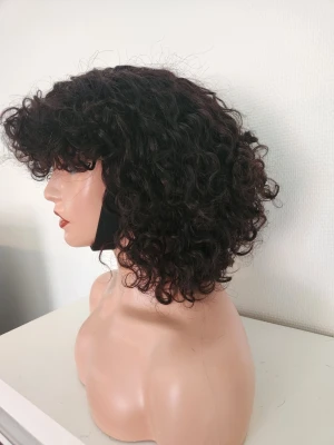 100% human hair, äkta curly wig Fringe Svart lockig peruk med lugg - Snygg svart lockig peruk med kort längd och lugg framtill. Peruken har täta, definierade lockar och en naturlig volym. Perfekt för dig som vill förändra din look snabbt och enkelt. Passar både till cosplay och vardagsstil.