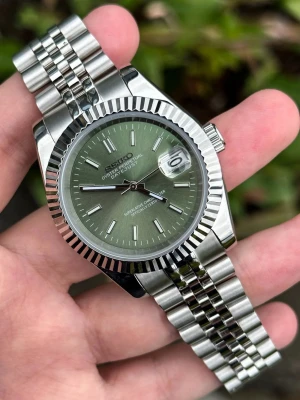 Seiko Date-just Mod Olive Green Dial Mod 36/39 - -Movement: NH35 Seiko -Case Size: 36mm or 39mm -Water Resistance: 100m -Crystal: Sapphire Glass -Lume: Super Lume -Case & Bracelet: 904L Stainless Steel