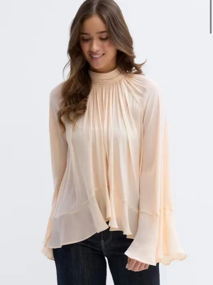 Peach boho grill blouse GinaTricot - Superfin peach färgad blus i ett flowy, tunt material med hög hals och långa, vida ärmar. Blusen har volangdetaljer och ett lätt glansigt tyg som ger en lyxig känsla. Perfekt att styla med jeans eller kjol för en trendig look. Helt ny med prislapp! Slutsåld hos Gina