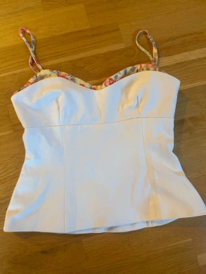 Vit korsettopp med blommiga band - Snygg vit korsettopp från Zara, nästintill oanvänd. 🤍