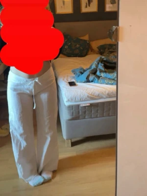 Vita linnebyxor - Vita linnebyxor med raka ben, dragsko i midjan och unika bakfickor. Observera att det är en liten bristning i en av sömnarna precis vid dragkedjan framtill, men det är inget som syns när byxorna är på. 