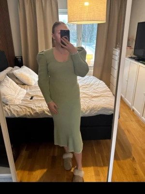 Ljusgrön ribbad stickad långklänning, Adoore - Säljer en ljusgrön, ribbad stickad långklänning med lång ärm och rund halsringning. Klänningen har en figurnära passform och lätt volangkant nertill. Perfekt för dig som gillar en enkel men ändå trendig look.