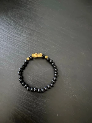 Svart armband med gulddetalj - Säljer mitt svarta armband som har en fin guld detalj. Detta armband är helt nytt och passar alla då den är töjbar och sätter sig perfekt på din handled. Du får denna för endast 45 kronor. Skickar snabbt inom 24h! 🚛📦Priset går att diskuteras vid en snabb affär🤝💯
