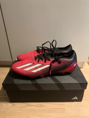 Röda Adidas fotbollsskor med dobbar - Snygga fotbollsskor från Adidas i rött och svart med klassiska vita ränder på sidan. Skorna har snörning, låg profil och dobbar för bra grepp på planen. Säljer för att dem är för små. Dem kommer med box, ej med påse. Pris kan diskuteras.